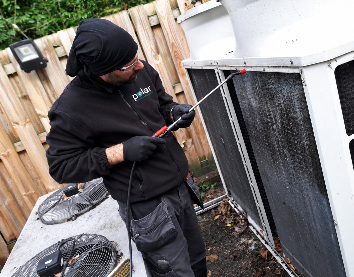 Polar engineer treating an outdoor unit coil