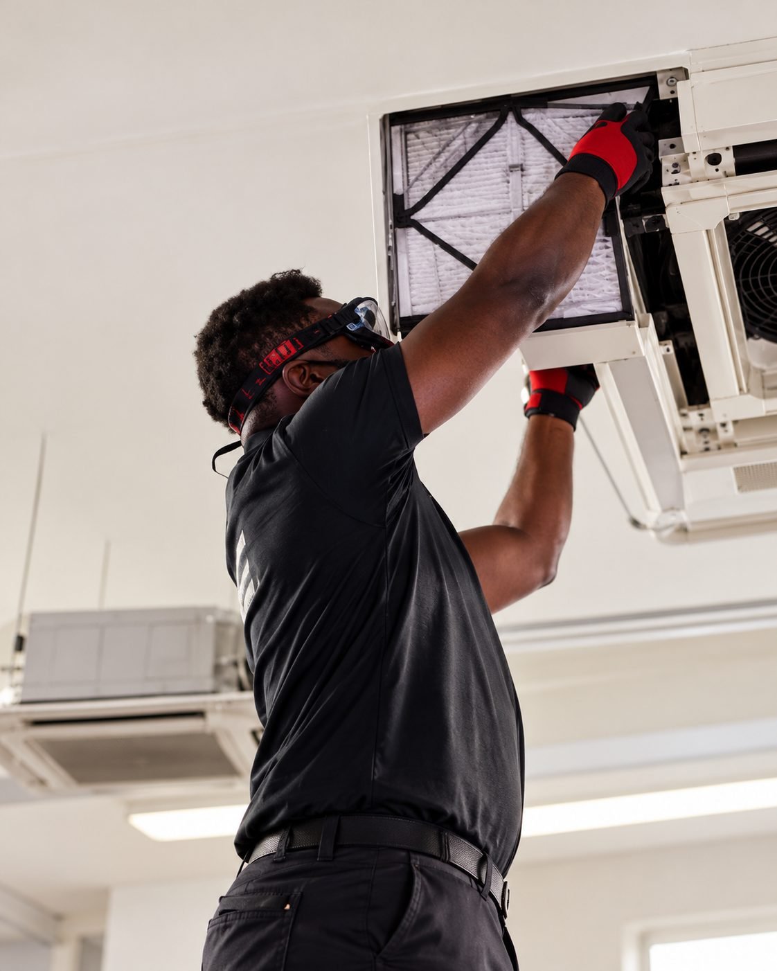 Engineer replacing the filter in a ceiling cassette unit