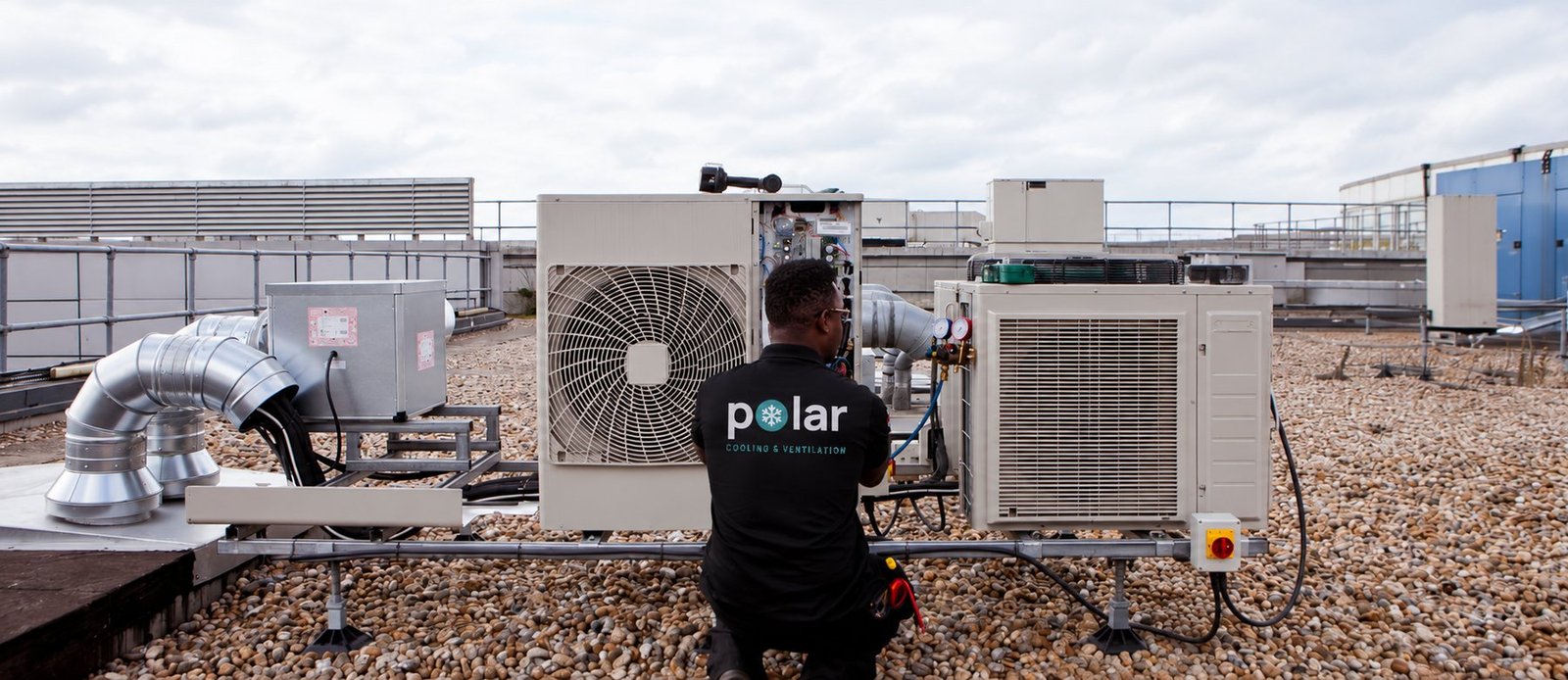 Polar engineer commissioning outdoor condensing units on a rooftop